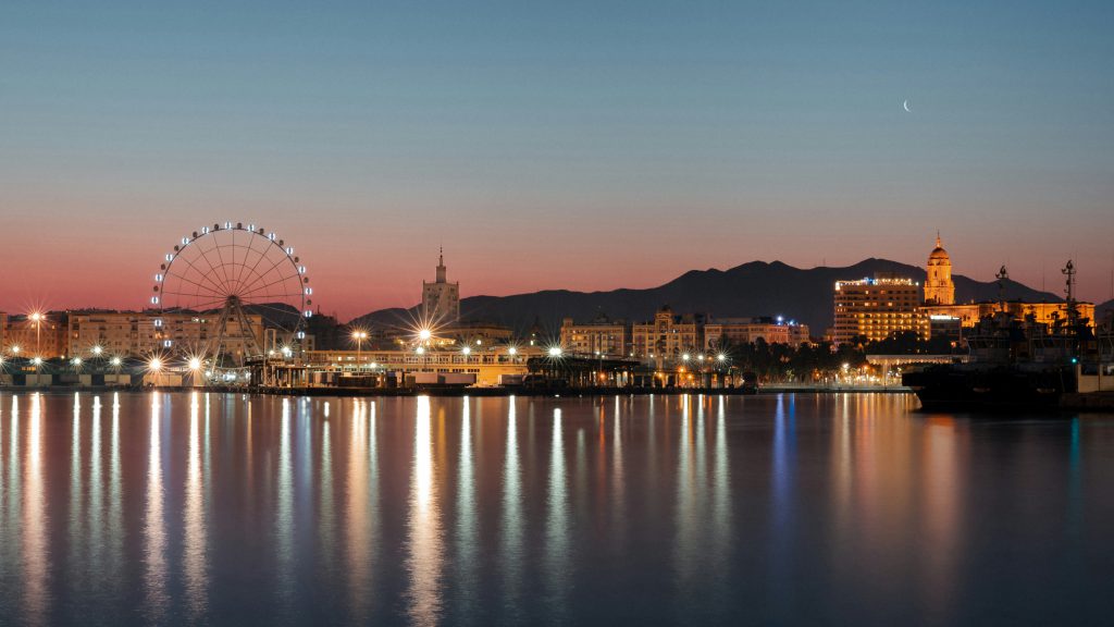Málaga Muelle Uno havn-promenade med butikker, restauranter, palmetrær og havutsikt.