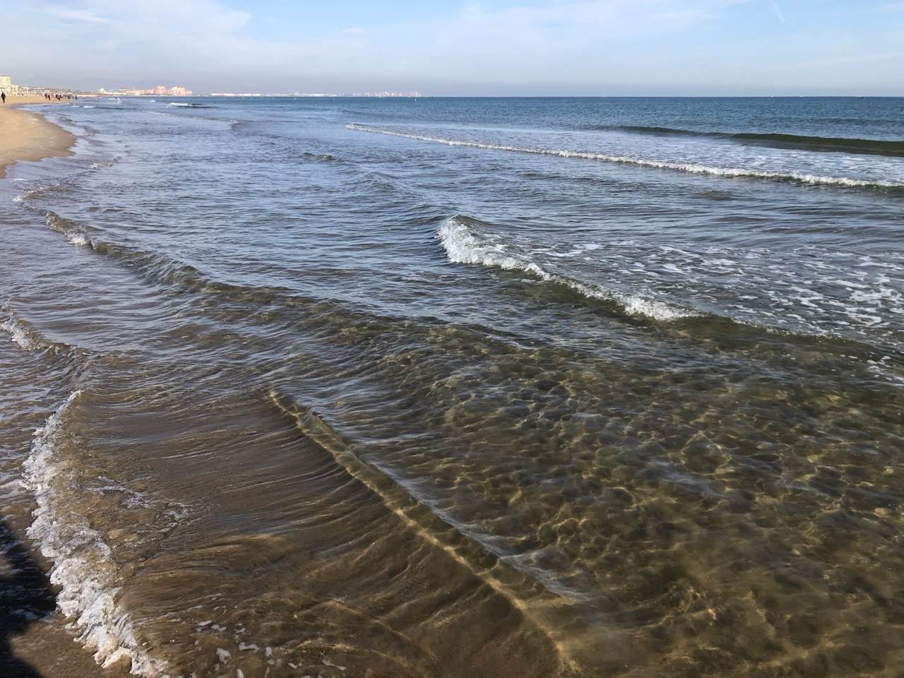 Malvarrosa strand i Valencia med gylden sand, palmer, strandpromenade og mennesker på stranden