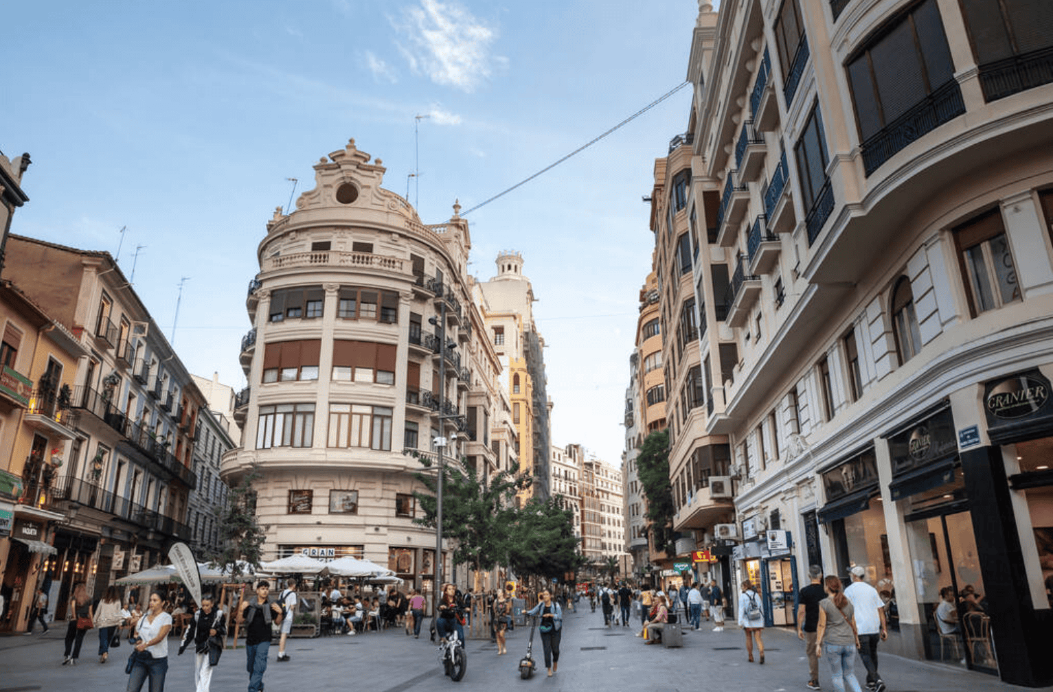 Calle Don Juan de Austria luksus shoppinggate i Valencia med palmetrær, lys og fotgjengere ved solnedgang